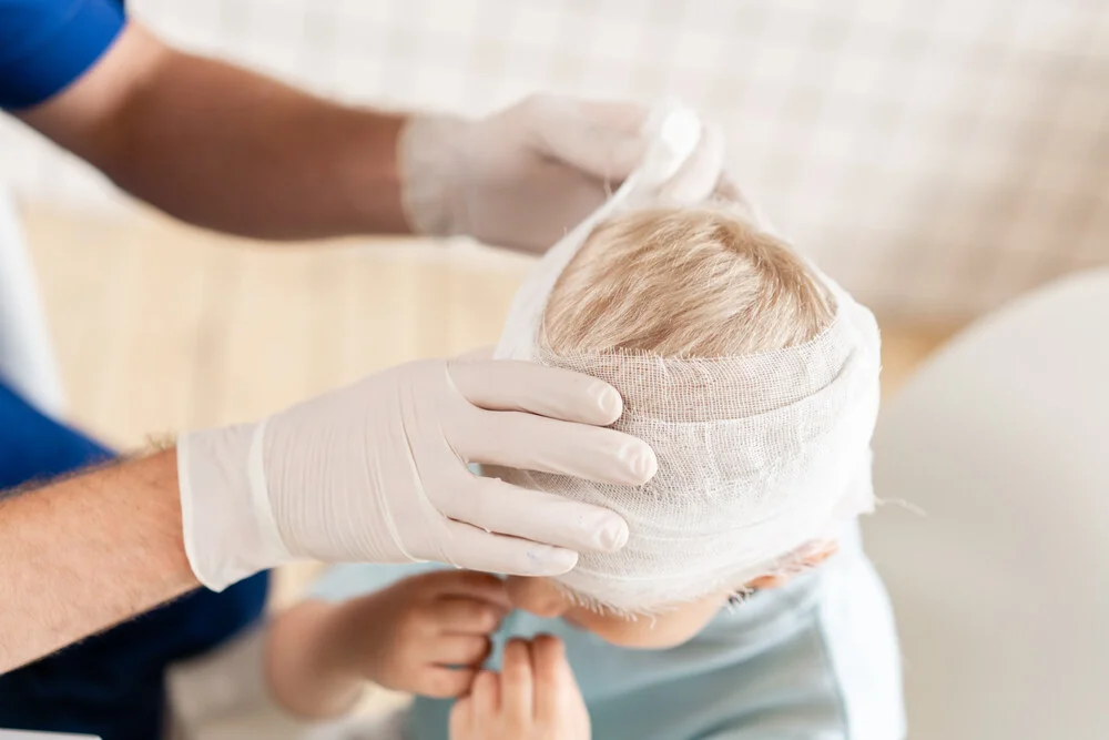 Doctor bandaged a boy head with trauma in his head and elastic bandaged around his head

